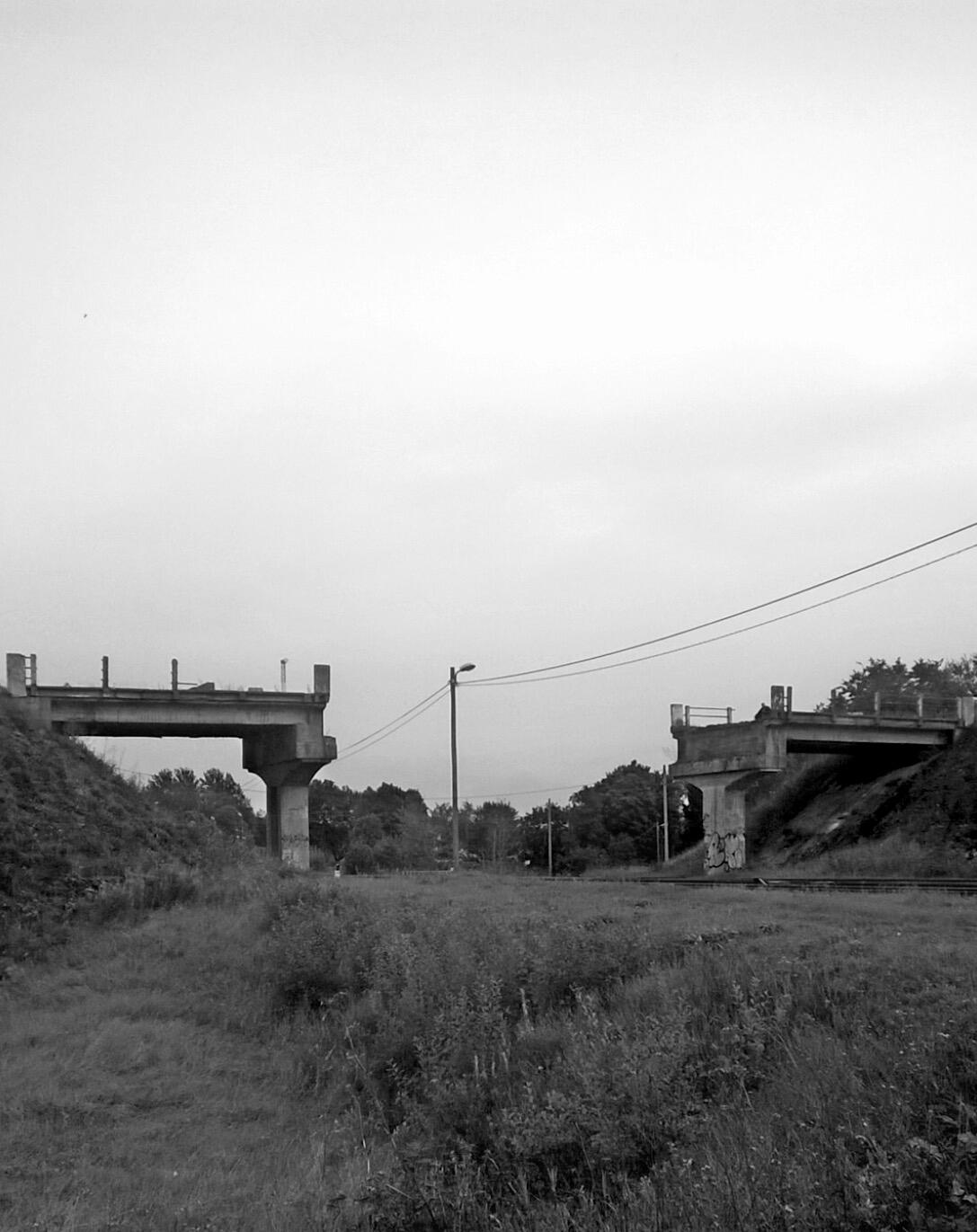 Vertical black-and-white photo of a broken bridge in Viivikonna, Estonia, part of Emotional Heritage series
